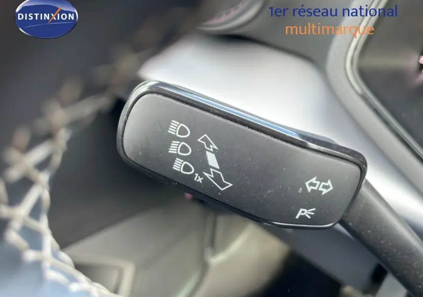 Gros plan sur la commande de clignotant noire dans l’habitacle d’une SEAT Ibiza bleu Fjord 2025.