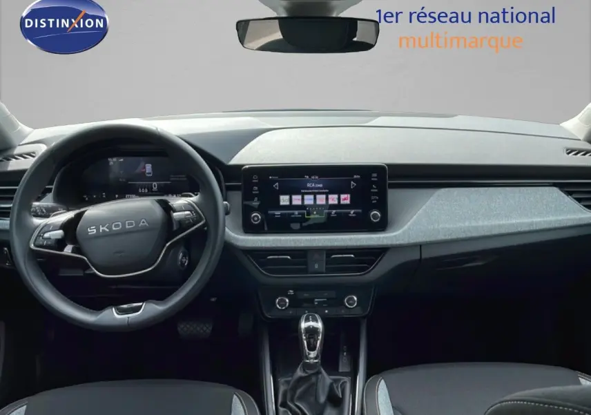 Vue intérieure frontale du tableau de bord de la Skoda Scala 2025 avec volant multifonction et écran tactile central.