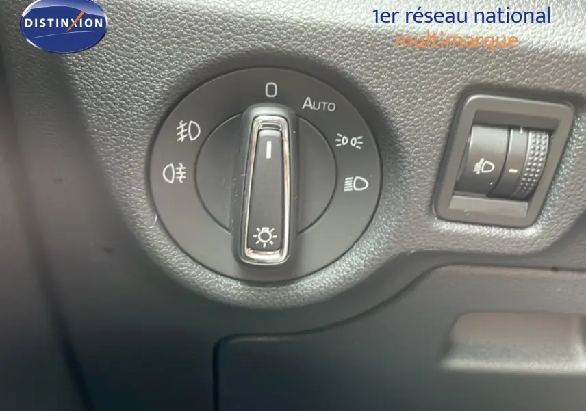 Gros plan sur le bouton de commande des phares dans l’habitacle d’une Skoda Scala 2025 bleu racing metal.