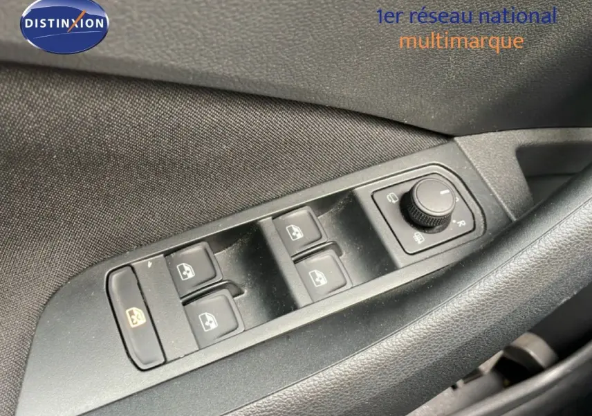 Gros plan sur les commandes de lève-vitres et réglage des rétroviseurs côté conducteur d'une Skoda Scala Bleu Racing Metal.