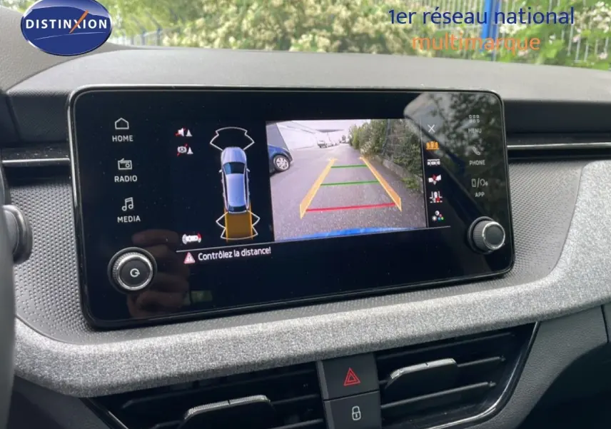 Écran central de la Skoda Scala bleu Racing Metal montrant la caméra de recul avec guidage de trajectoire.