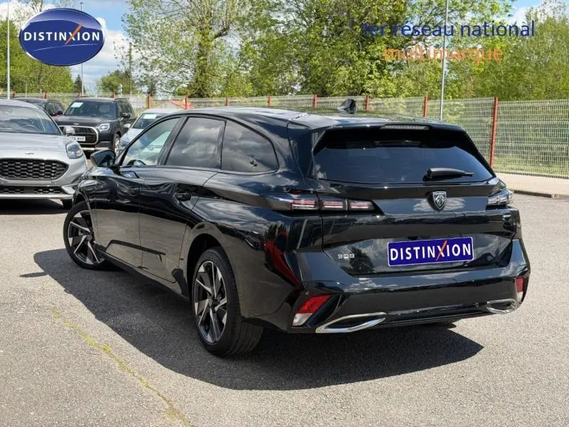 Peugeot 308 SW hybride noire vue 3/4 arrière droit, avec jantes alliage et feux arrière LED distinctifs.