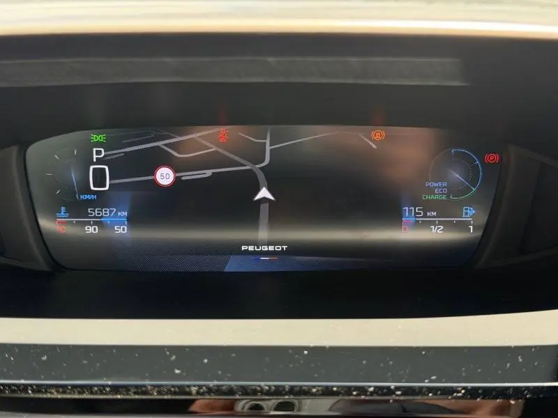 Tableau de bord numérique du Peugeot 308 SW Hybrid 2025, affichant la navigation, vitesse à 0 km/h et autonomie hybride.