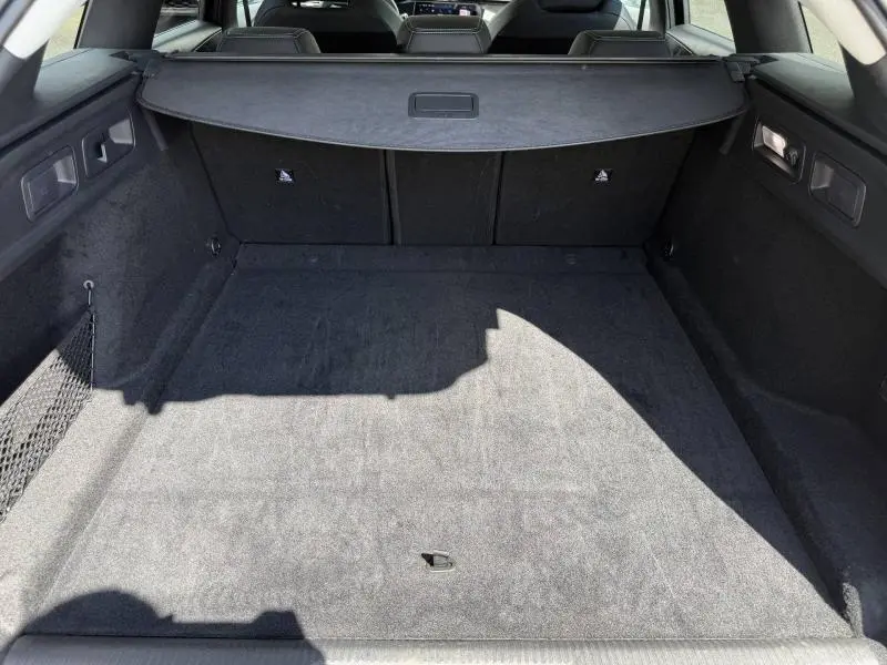 Vue intérieure du coffre spacieux et propre du Peugeot 308 SW 2025 en Noir Perla Nera, avec cache-bagages déployé.