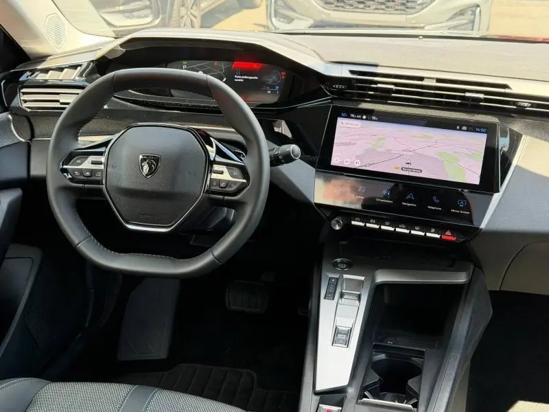 Vue intérieure centrée sur le volant et la console centrale avec écran tactile du Peugeot 308 SW 2025 noir Perla Nera.