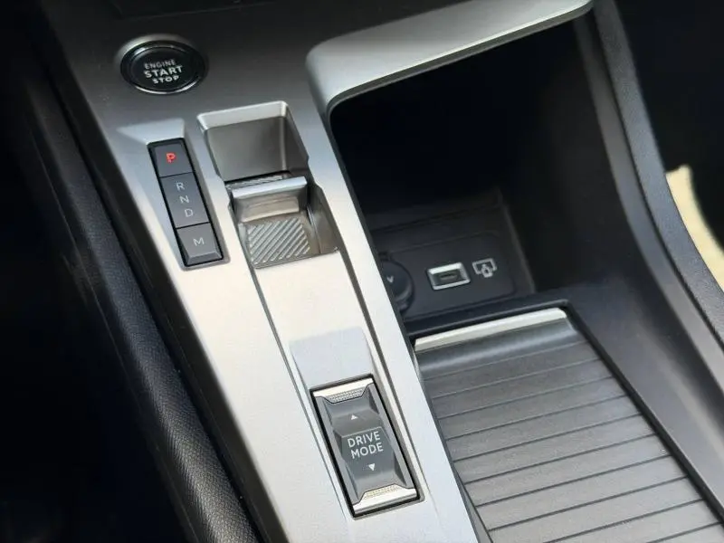 Gros plan sur la console centrale argentée du Peugeot 308 SW 2025 avec boutons de boîte auto et mode de conduite.