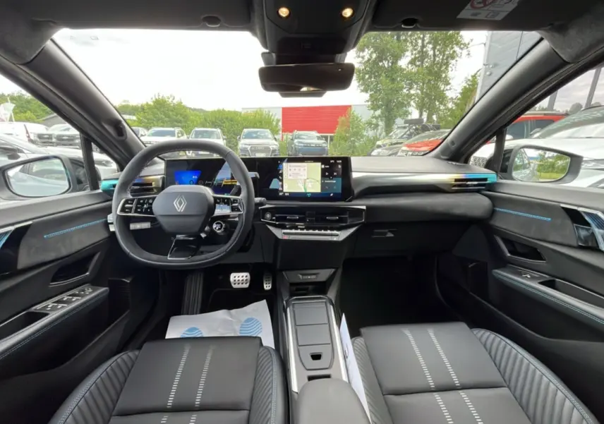 Vue intérieure avant de la Renault Clio 6 E-Tech Esprit Alpine avec tableau de bord numérique et finitions noires et bleues.