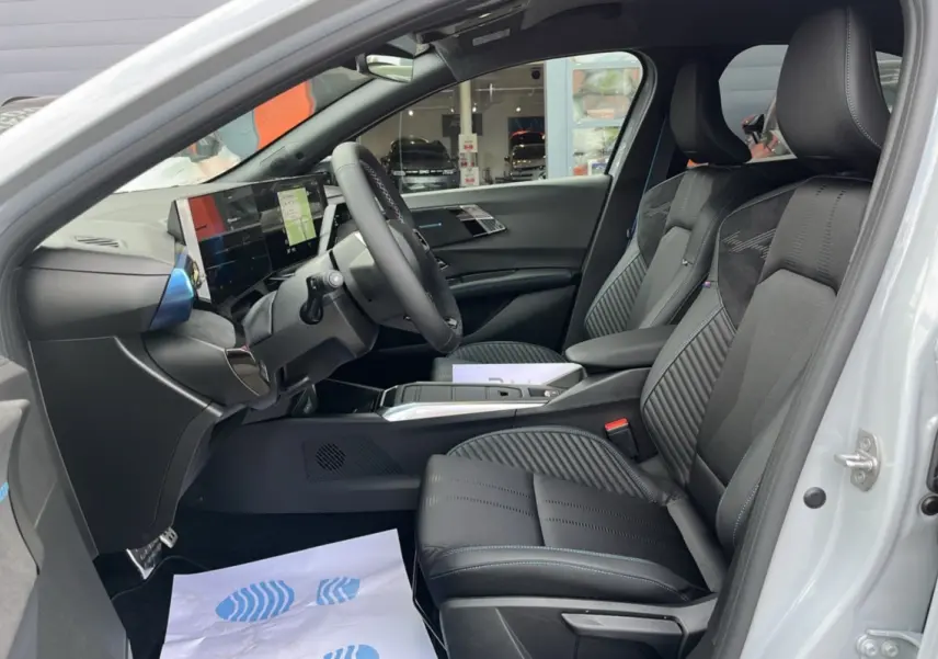 Vue intérieure côté conducteur de la Renault Clio 6 E-Tech 160 Esprit Alpine avec sièges sport noirs et tableau de bord numérique.