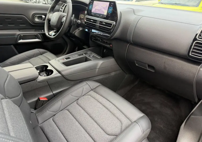 Intérieur avant du Citroën C5 Aircross 2025, vue côté passager, sièges tissu noir et tableau de bord moderne.