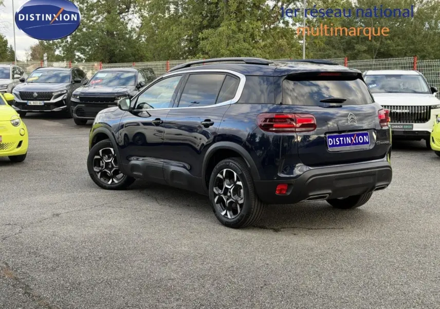 Citroën C5 Aircross Bleu Eclipse vue 3/4 arrière droit avec jantes alu et barres de toit visibles.