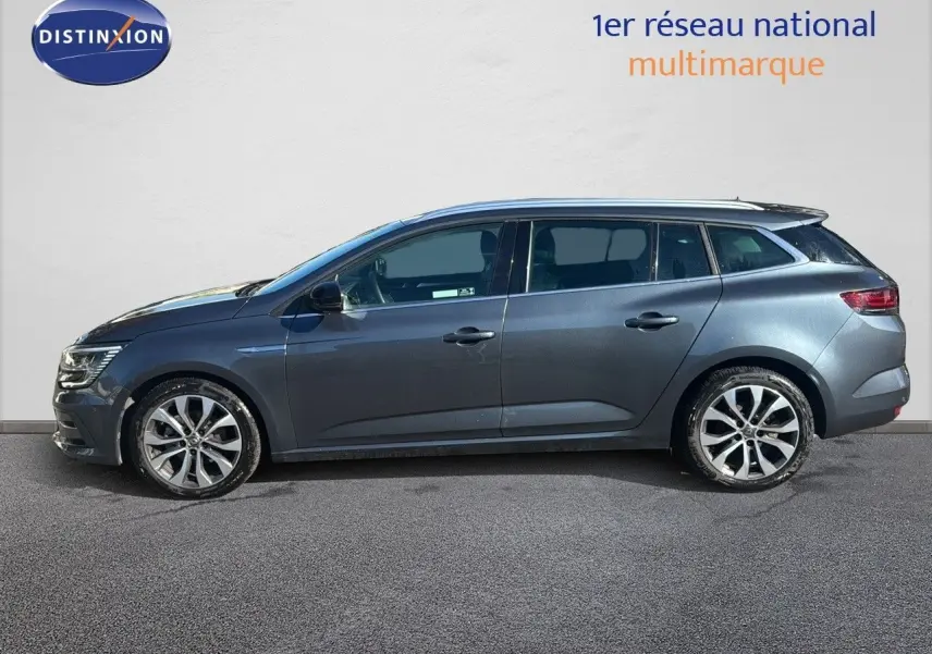 Profil côté gauche d'une Renault Mégane Break gris titanium métal 2024 avec jantes alliage bicolores.