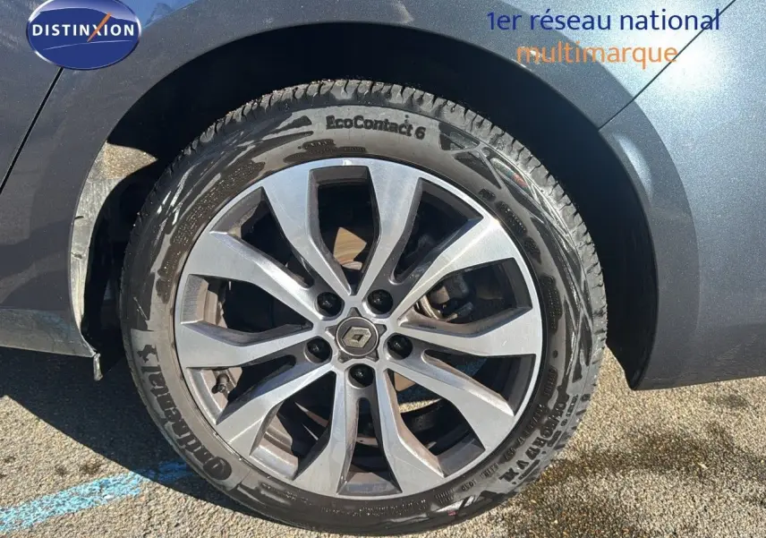 Gros plan sur la roue avant droite d'une Renault Mégane Break gris titanium avec jante alliage à 10 branches.
