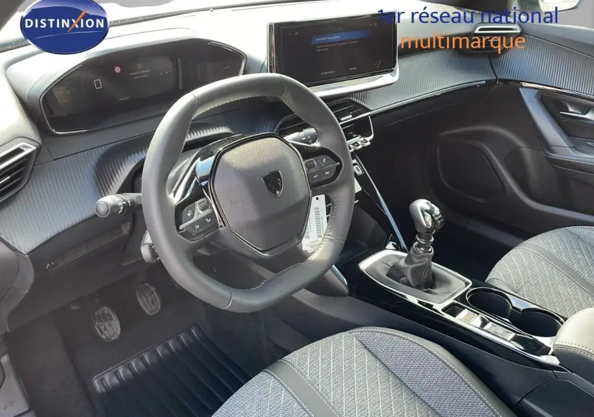 Intérieur du Peugeot 2008 2025, vue côté conducteur sur le volant compact, levier de vitesse manuel et écran tactile central.