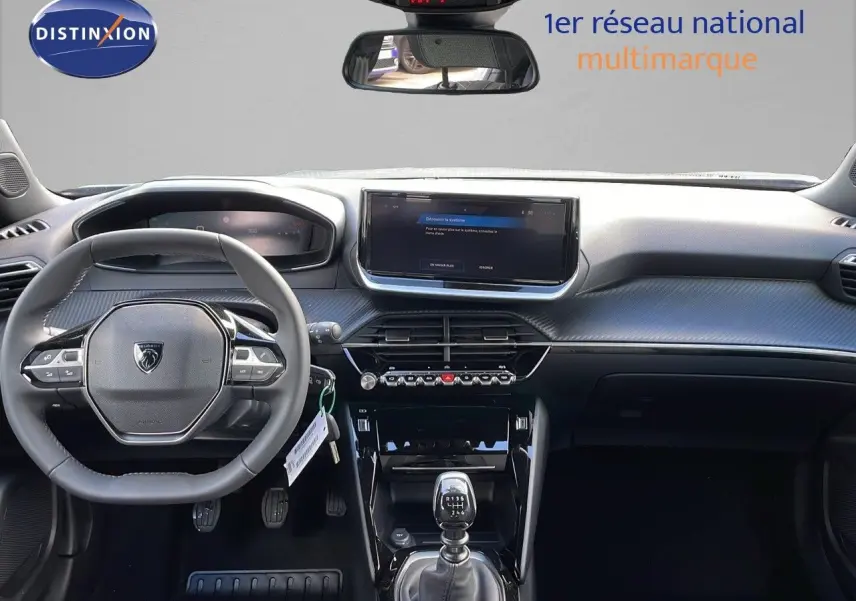 Vue intérieure frontale du tableau de bord et volant gris d'une Peugeot 2008 2025 avec boîte manuelle et écran tactile central.