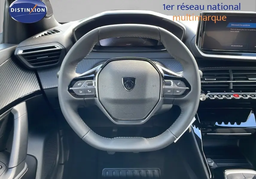Vue rapprochée du volant cuir noir et du tableau de bord moderne du Peugeot 2008 gris Artense 2025.