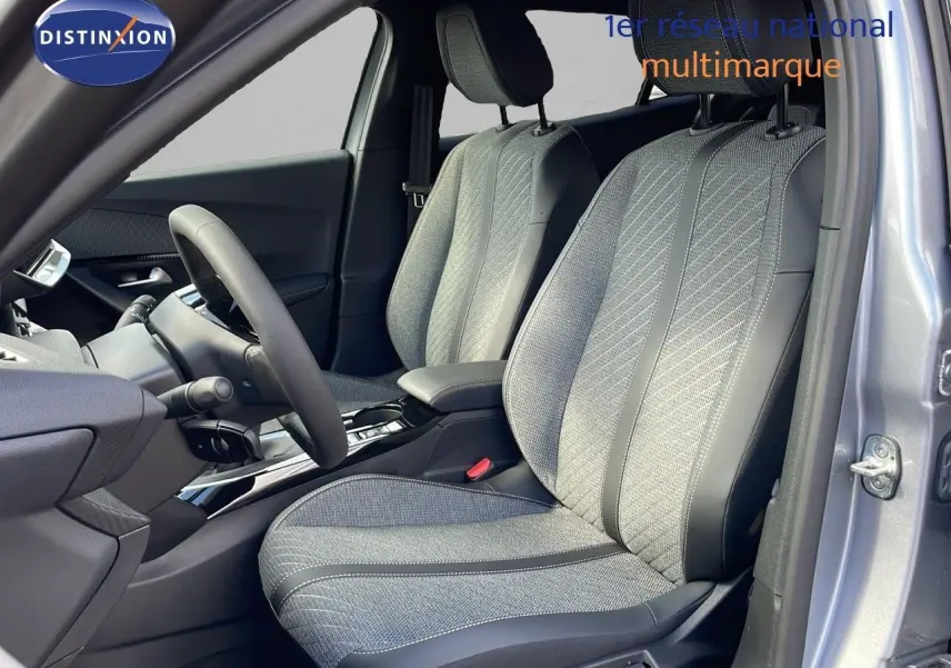 Vue intérieure côté gauche du Peugeot 2008 2025 gris Artense, sièges tissu et cuir noir avec console centrale moderne.