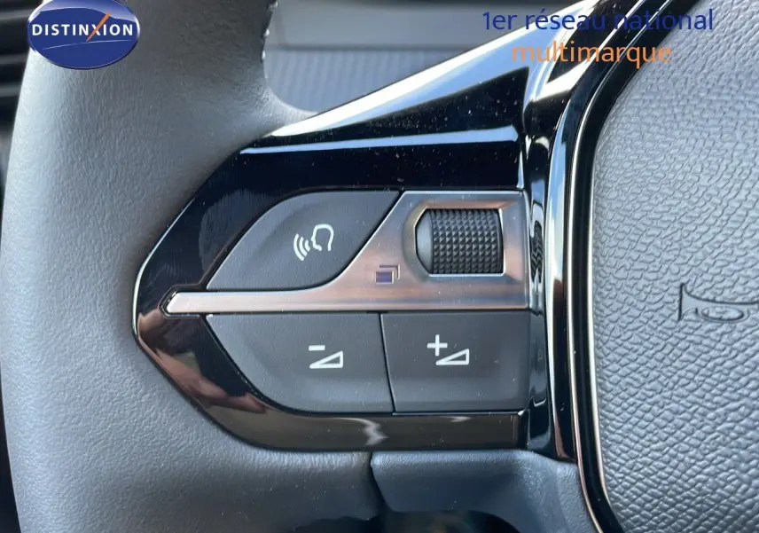 Gros plan sur les commandes de volume au volant du Peugeot 2008 gris Artense Métal, finition Allure 2025.