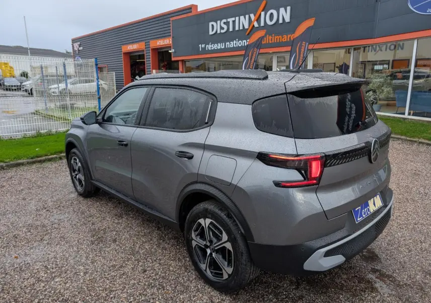 Vue 3/4 arrière droite du Citroën C3 Aircross gris métallisé avec toit noir et jantes alliage diamantées.