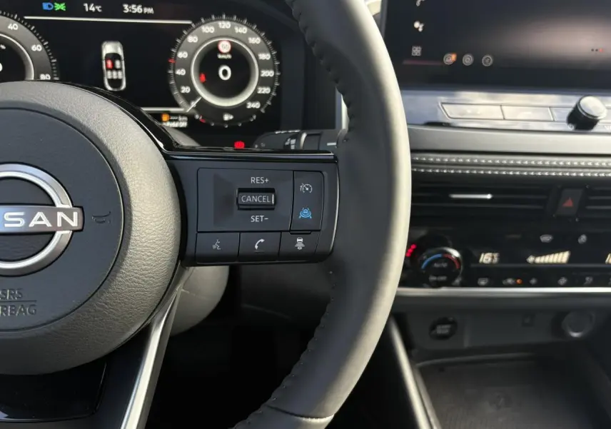 Gros plan sur le volant noir et le tableau de bord numérique du Nissan Qashqai 2025 avec commandes au volant visibles.