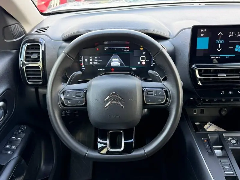 Vue intérieure centrée sur le volant du Citroën C5 Aircross gris 2024, avec tableau de bord digital et écran tactile.