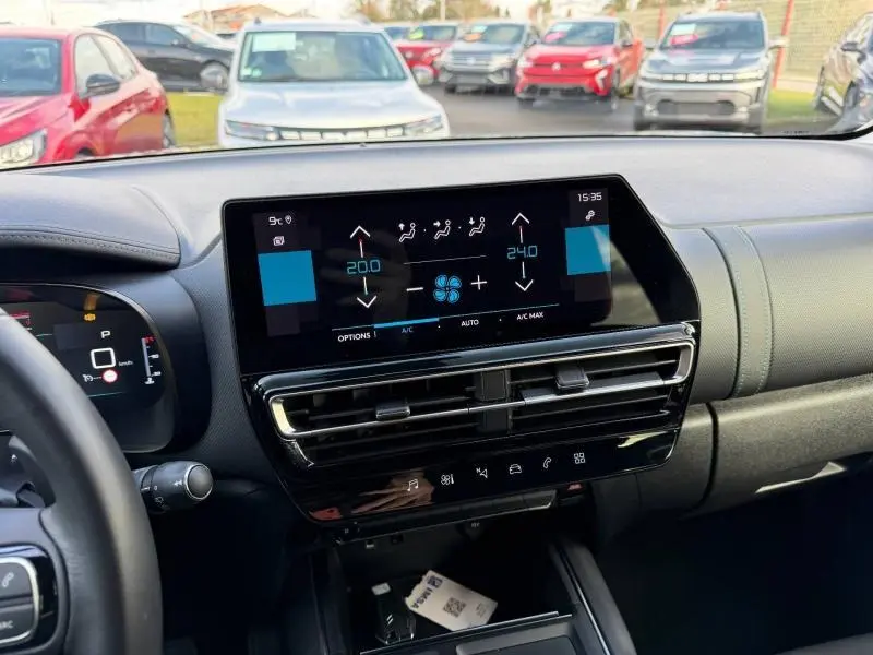 Vue intérieure du tableau de bord du Citroën C5 Aircross gris 2024, mettant en valeur l'écran tactile central et les commandes de climatisation.
