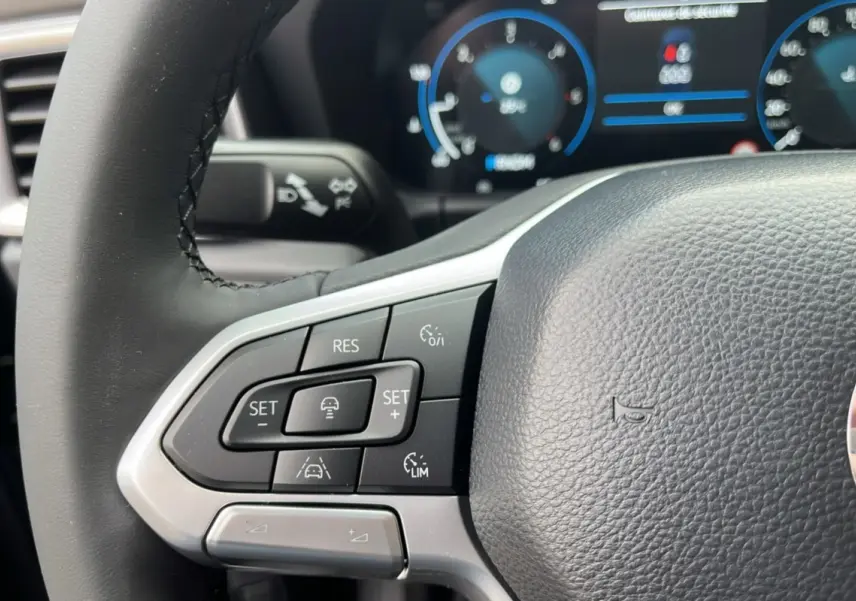 Gros plan sur le volant cuir noir du Volkswagen Amarok V6 240 BVA10 Aventura avec commandes multifonctions.