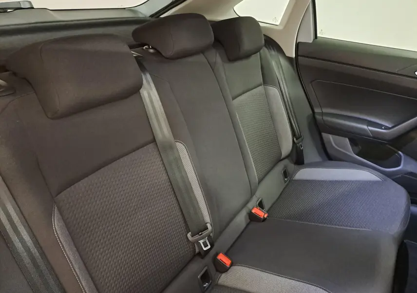 Vue intérieure du siège arrière droit du Volkswagen Taigo 2025, tissu noir avec détails gris et ceintures visibles.