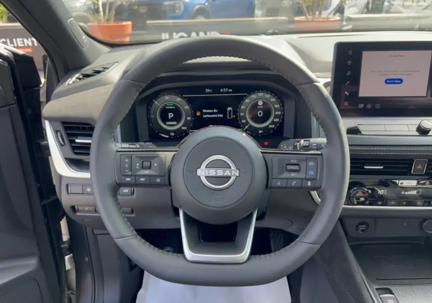 Vue centrée sur le volant cuir Nissan du Qashqai E-Power 205 Tekna Plus avec tableau de bord numérique et écran tactile.