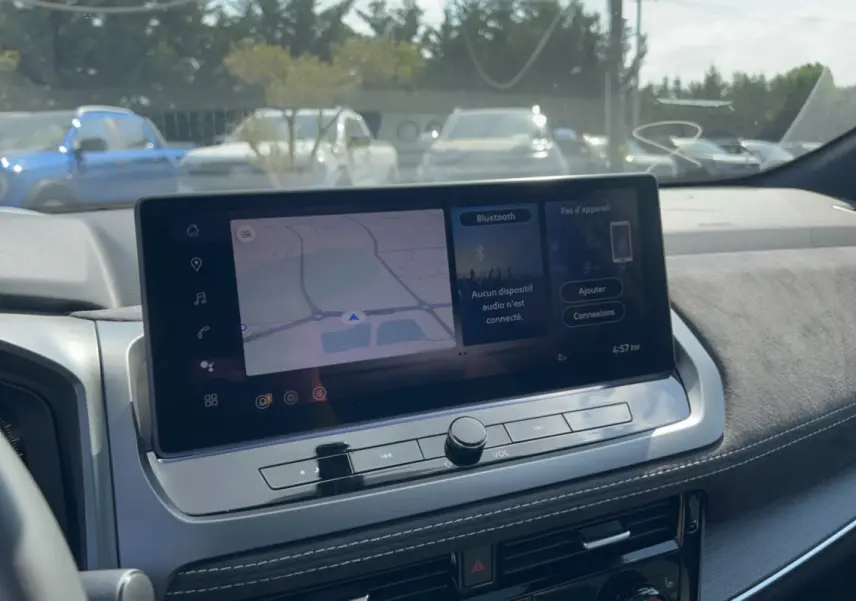 Vue rapprochée de l’écran tactile central du tableau de bord du Nissan Qashqai gris squale, affichant la navigation GPS.