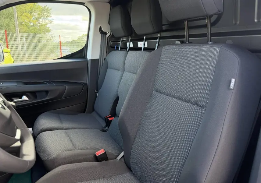 Vue intérieure côté conducteur du Peugeot Partner 2026, montrant la banquette avant 2 places en tissu gris Curitiba Triton Meltem.