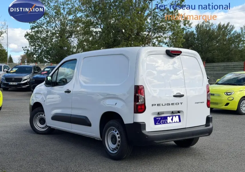 Vue 3/4 arrière droite du Peugeot Partner blanc Icy utilitaire avec portes arrière battantes et protections latérales noires.