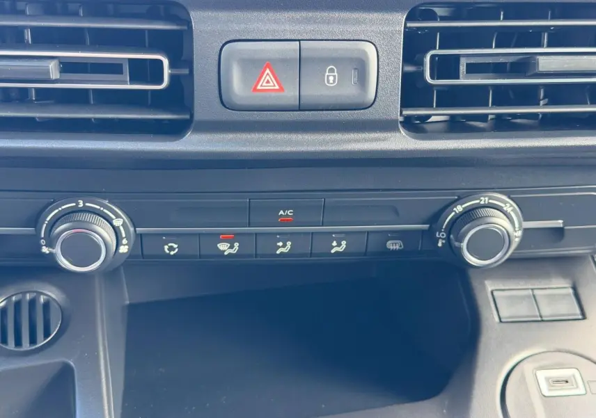 Vue rapprochée du tableau de bord du Peugeot Partner 2026 montrant les commandes de climatisation et ventilation.