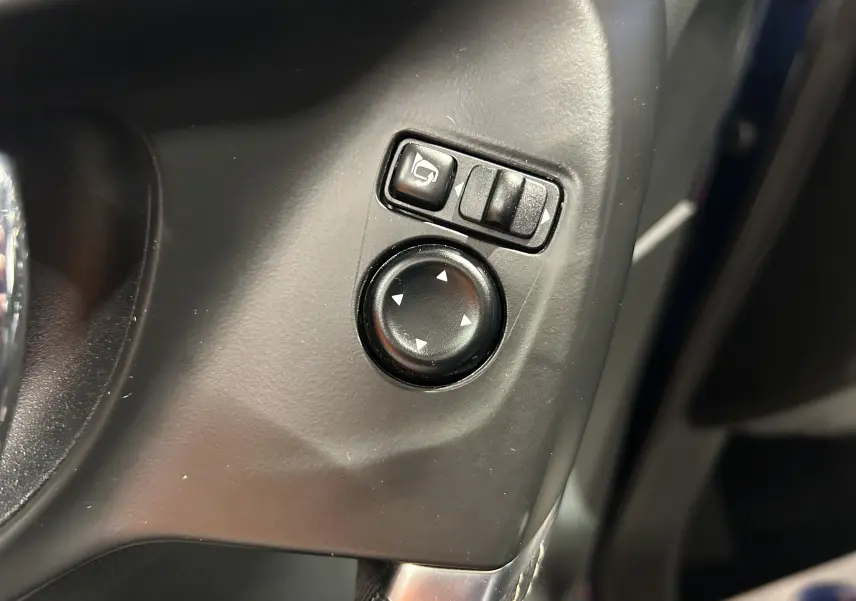 Gros plan sur les commandes de réglage des rétroviseurs côté gauche du tableau de bord du Renault Kadjar bleu 2017.