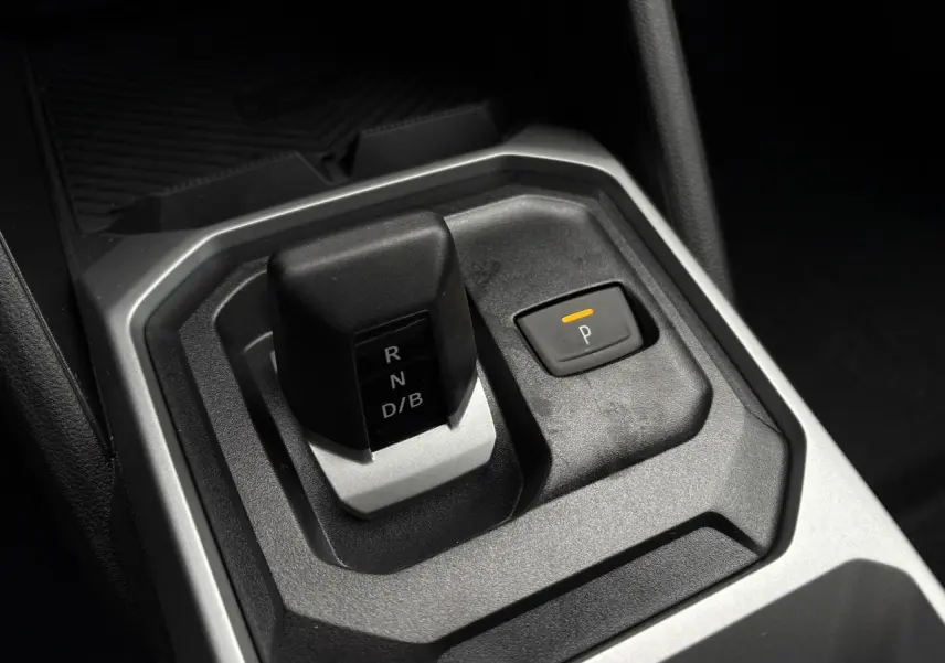 Le levier de boîte automatique noir et gris du Dacia Duster 1.6 Hybrid 140 Journey en gros plan intérieur.