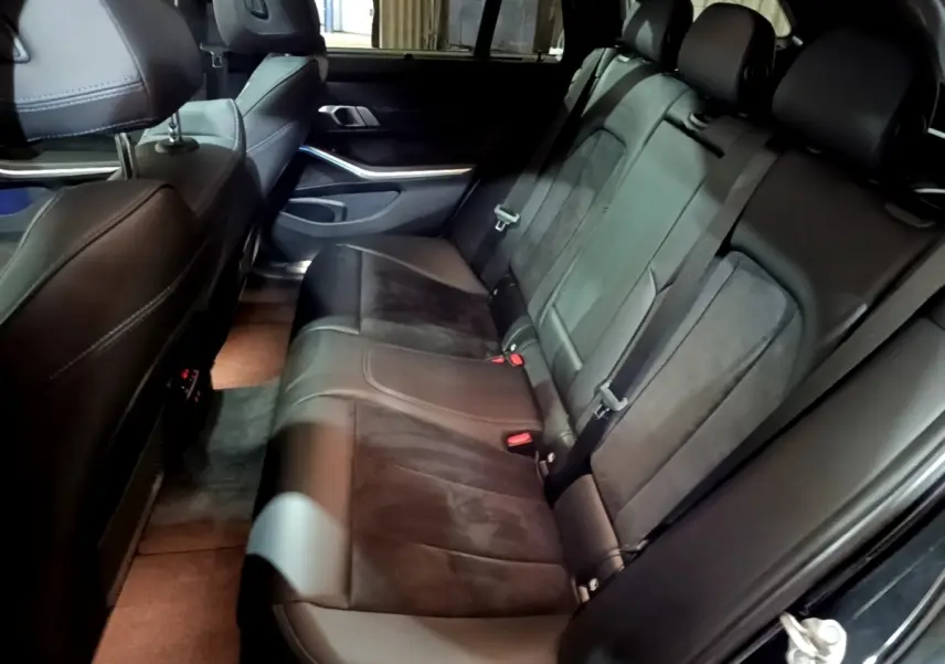 Vue côté droit de la banquette arrière en cuir noir et alcantara de la BMW Série 3 318i M Sport 2022.
