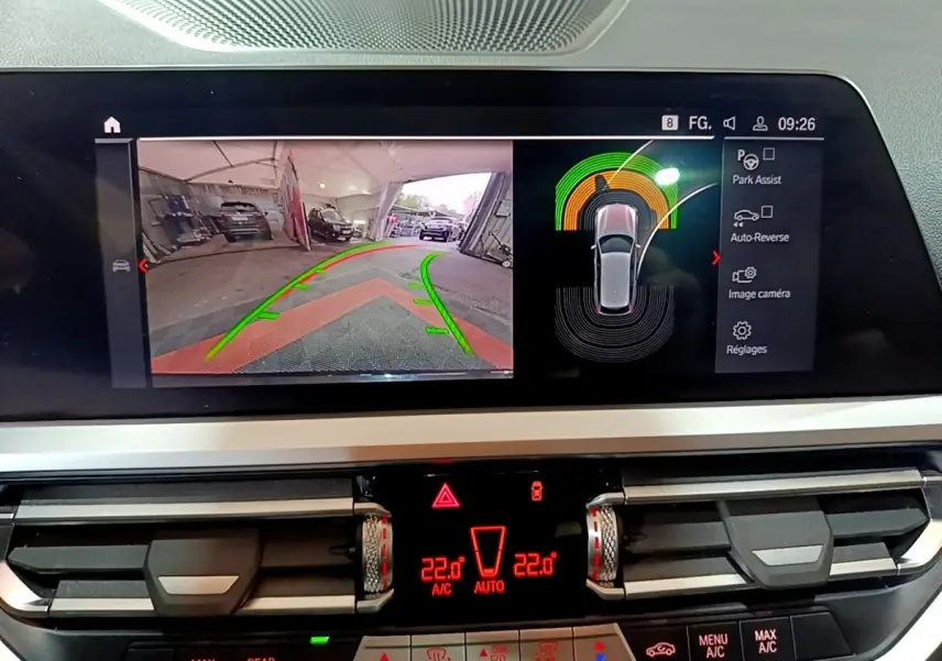 Écran tactile central de BMW Série 3 318i noir montrant l'aide au stationnement avec vue caméra arrière et capteurs.