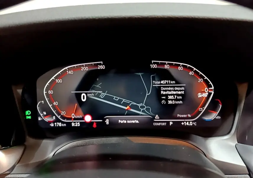 Tableau de bord numérique de BMW Série 3 318i noir, affichage vitesse, navigation et alertes, vue frontale rapprochée.