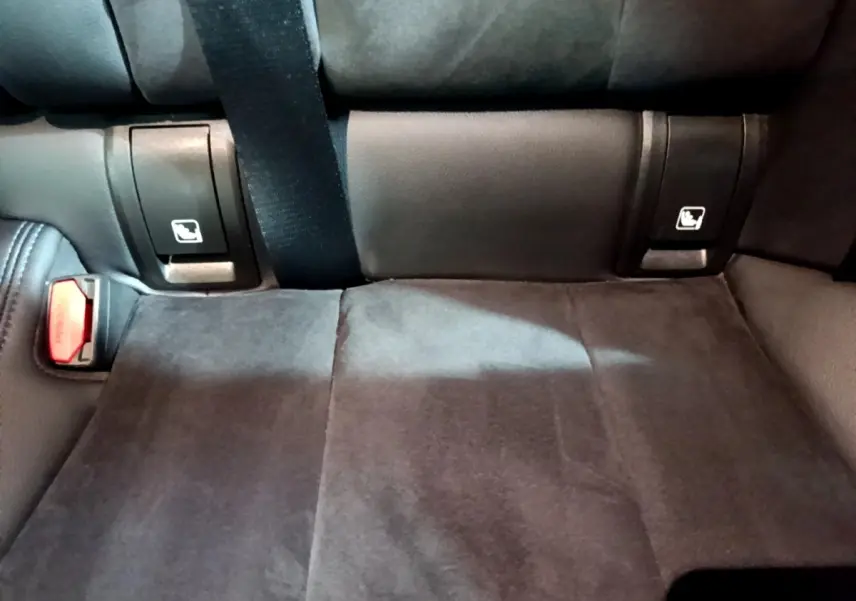 Détail de la banquette arrière noire de la BMW Série 3 318i M Sport avec ceintures et fixations Isofix visibles.