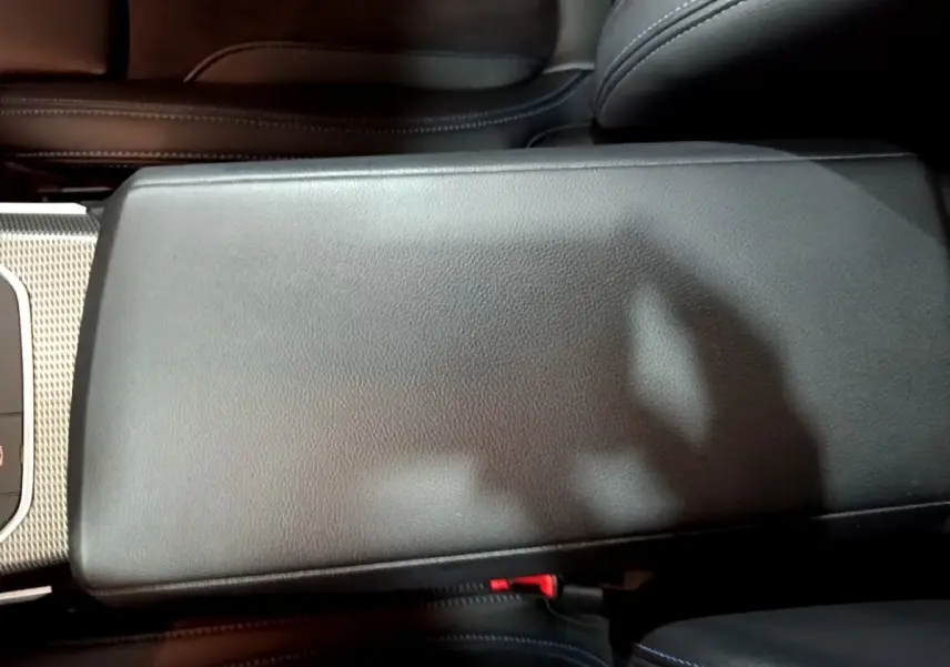 Gros plan sur l'accoudoir central en cuir noir de la BMW Série 3 318i M Sport 2022, intérieur élégant.