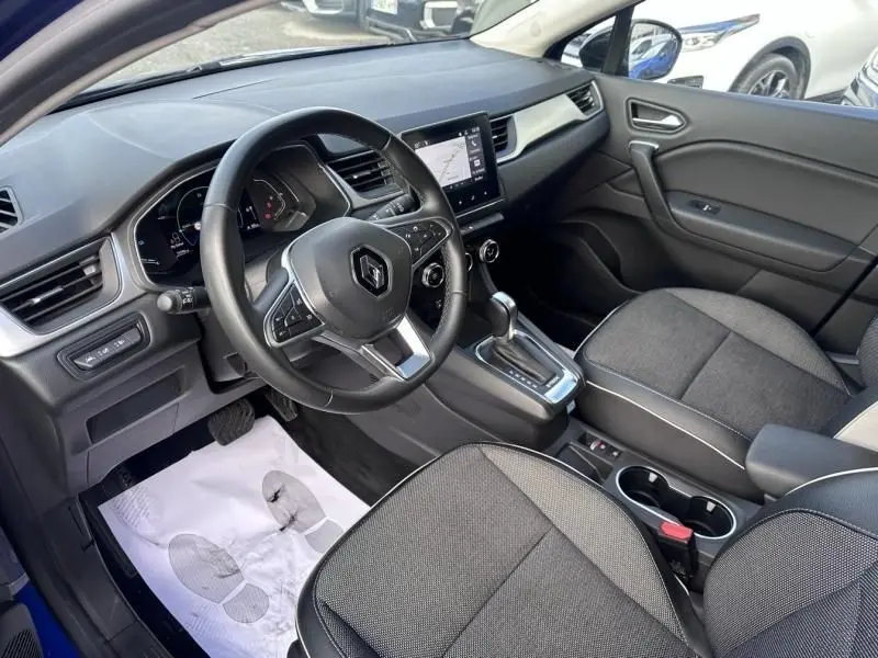 Vue intérieure côté conducteur du Renault Captur 1.6 E-Tech Hybride 145 Intense 2022, avec tableau de bord moderne et sièges gris.