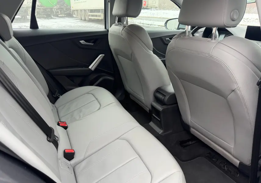 Vue intérieure arrière de l'Audi Q2 2017, sellerie similicuir gris clair avec sièges arrière et avant visibles.