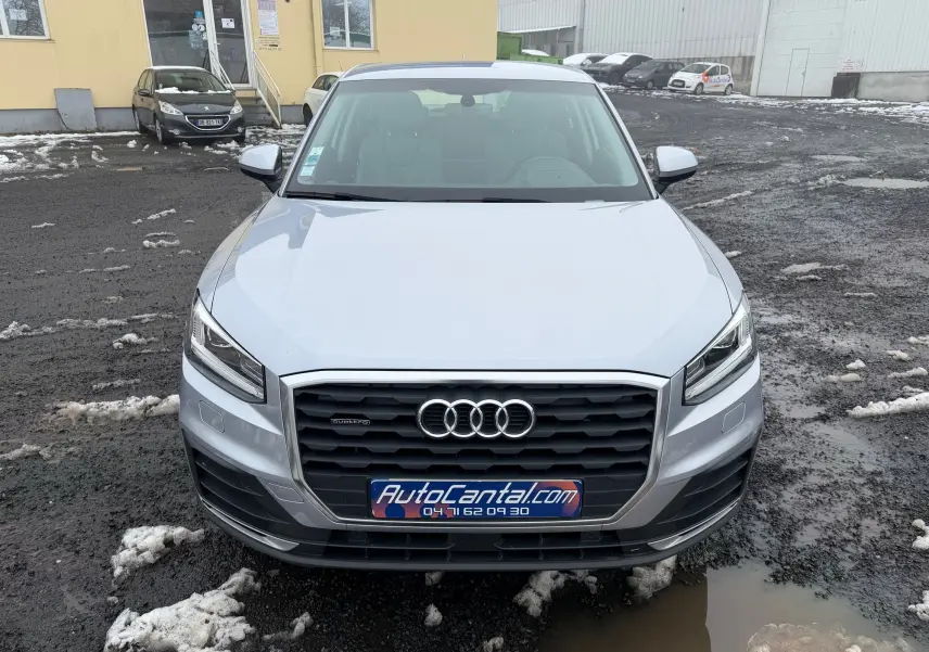 Vue avant d'un Audi Q2 gris aluminium 2017 avec calandre noire et logo quatre anneaux bien visible.
