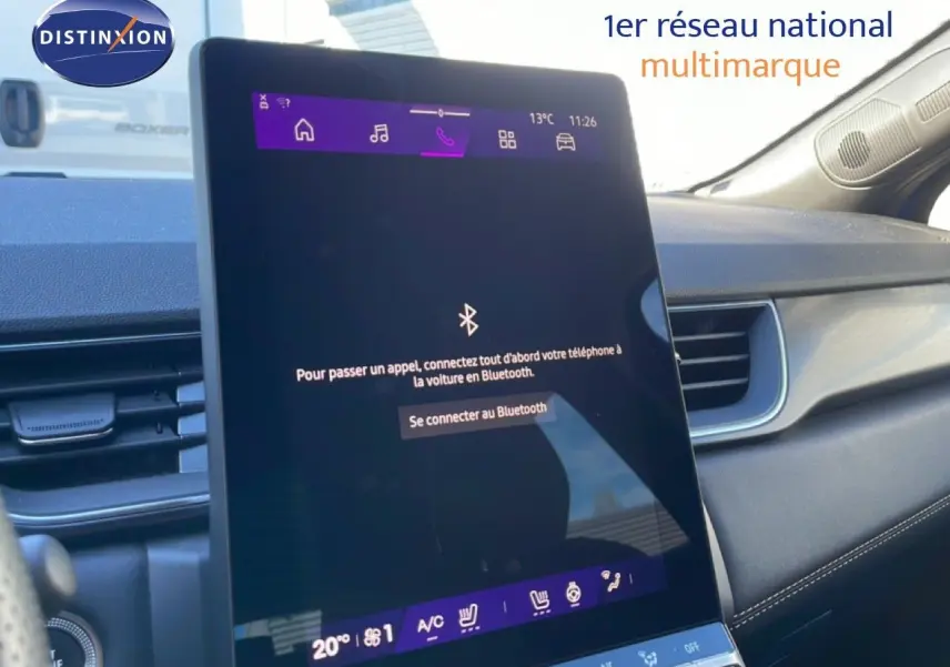 Vue intérieure centrée sur l'écran tactile du tableau de bord du Renault Symbioz bleu Iron Metal, affichant la connexion Bluetooth.