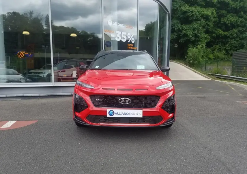 Vue frontale d'un Hyundai Kona rouge 2023 avec toit noir contrasté et calandre N Line distinctive.