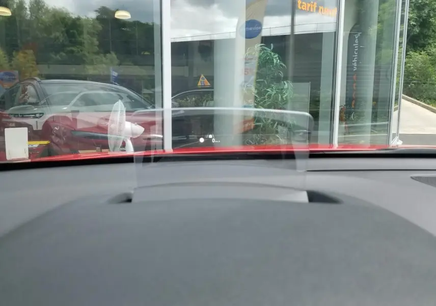 Vue intérieure du tableau de bord du Hyundai Kona rouge 2023, avec affichage tête haute transparent en avant.