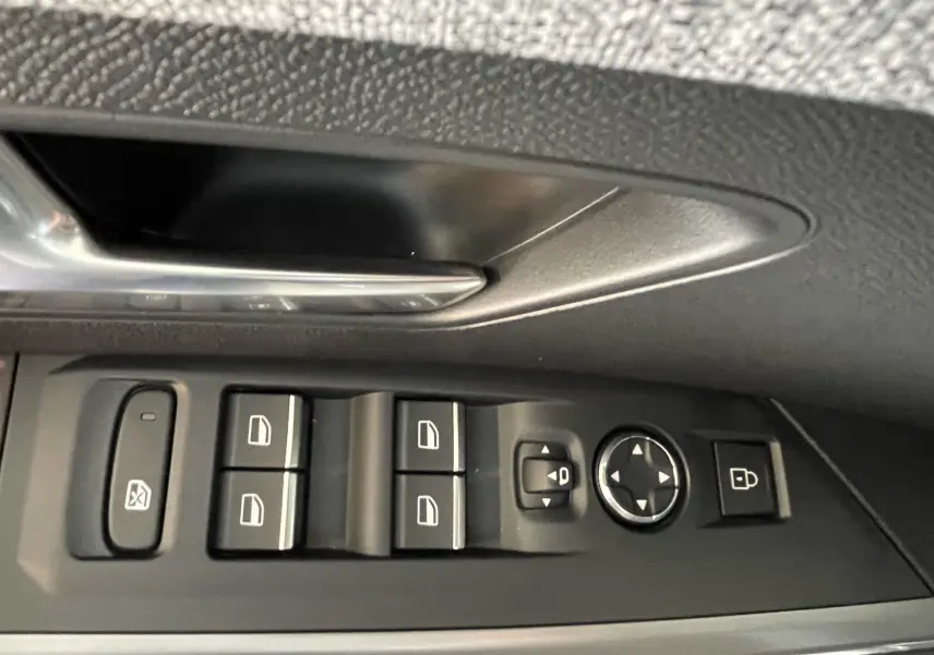 Gros plan sur les commandes de lève-vitres et rétroviseurs côté conducteur d’un Peugeot 3008 noir.