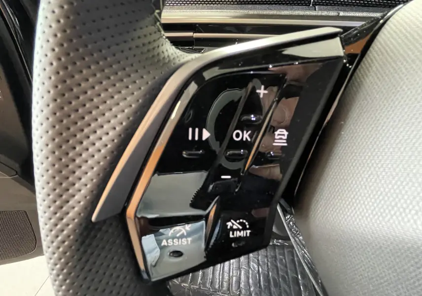 Gros plan sur les commandes de régulateur et assistance au volant perforé du Peugeot 3008 noir 2026.