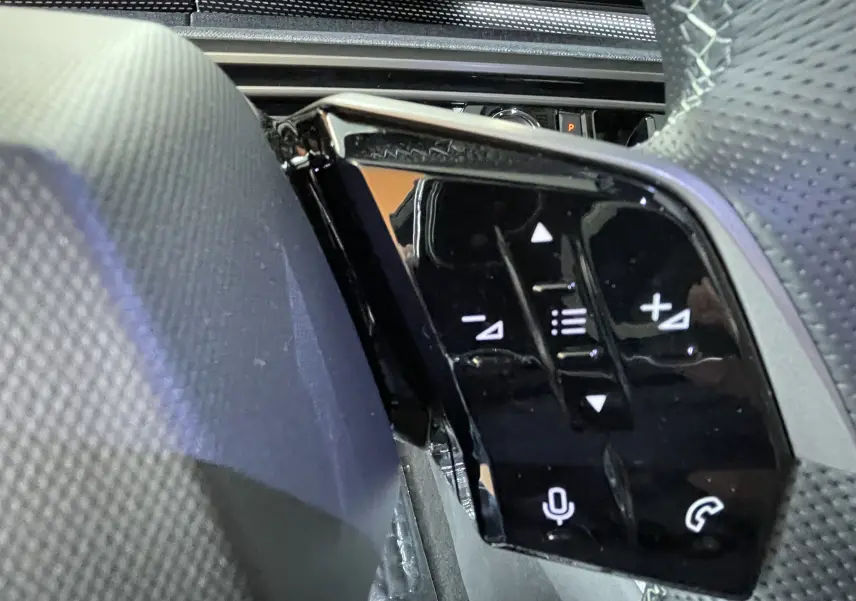 Gros plan sur les commandes tactiles noires du volant côté gauche du Peugeot 3008 Hybrid 145 GT Exclusive 2026.