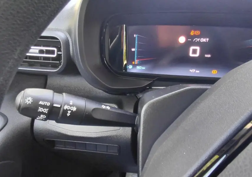 Vue rapprochée du tableau de bord du Citroën Berlingo 2025 essence, avec écran numérique et commande d’allumage automatique.