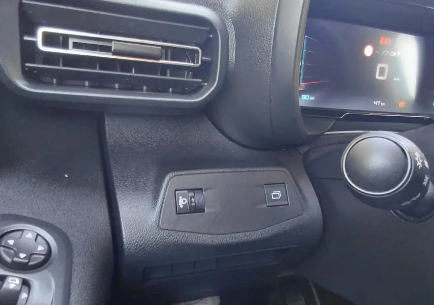 Vue rapprochée de l'intérieur du tableau de bord du Citroën Berlingo 2025, avec commandes et écran digital.